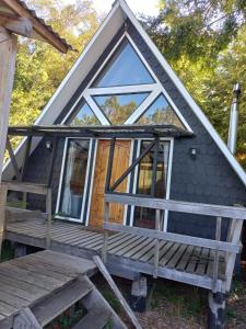 ein kleines Haus mit einer Veranda und Fenstern in der Unterkunft Donde Coco in Quellón