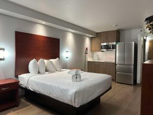 a hotel room with a bed and a kitchen at SureStay Plus by Best Western Brooks in Brooks
