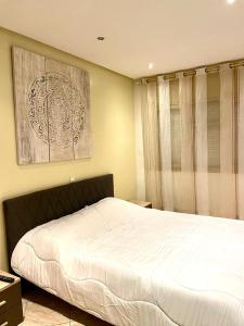 a bedroom with a bed and a picture on the wall at Luxurious Apartment Center Agdal Rabat in Rabat