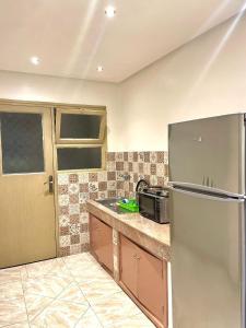 a kitchen with a refrigerator and a microwave at Luxurious Apartment Center Agdal Rabat in Rabat
