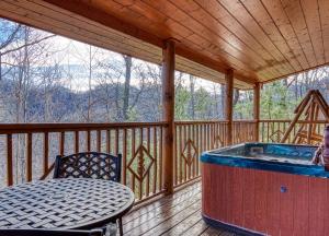 賽維爾維爾的住宿－Secluded Hideaway cabin，门廊设有热水浴池和甲板上的桌子