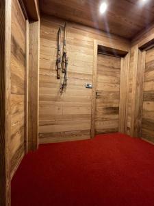 Habitación con paredes de madera y alfombra roja. en Case Vacanza Perron en Sauze dʼOulx