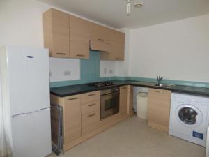 a kitchen with a white refrigerator and a washer at The Light Buildings in Preston