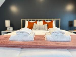 two towels sitting on top of a bed at Rivertown Retreat in Downtown Verona in Verona