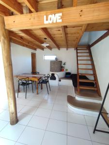 sala de estar con techo de madera, mesa y sillas en Alojamientos CUYEN para 2 o 3 personas Playa Quequen y El Faro en Quequén