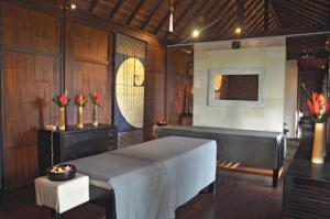 a room with a bed and a table and a bench at Awan Putih Resort Ubud in Payangan +32 photos