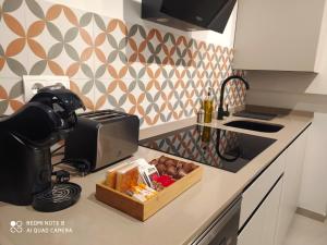 a kitchen counter with a toaster and a box of food at Apartamentos Bahía&Arena - Centro in Santander
