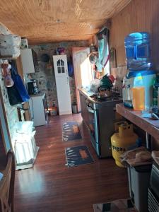 a kitchen with a stove and a wooden floor at Casa donde Angy - desde 2 noches in Papudo