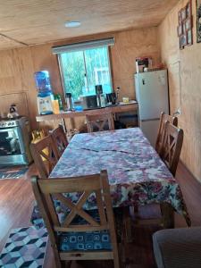 a kitchen with a table with chairs and a refrigerator at Casa donde Angy - desde 2 noches in Papudo