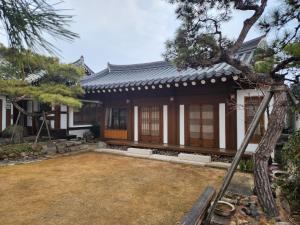 une maison japonaise avec un jardin en face dans l'établissement HanokInn, à Gyeongju