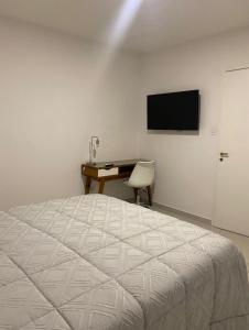 - une chambre avec un lit, un bureau et une télévision dans l'établissement Reconquista900, à Buenos Aires