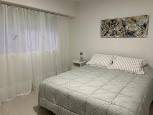 - une chambre blanche avec un lit et une fenêtre dans l'établissement Reconquista900, à Buenos Aires