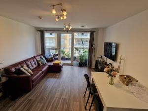 ein Wohnzimmer mit einem Sofa und einem Tisch in der Unterkunft Brixton Village Flat- Private En-suite double bedroom in London
