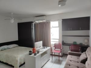 een slaapkamer met een bed en een bank bij Loft completo na Asa Sul próximo da P Federal ENAP LBV Aeroporto CASV , Rodov Interestadual e academia da PM in Brasilia