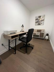an office with a desk with a laptop and a chair at Condo in Quebec City