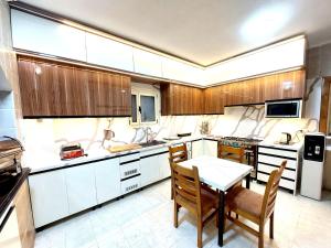 uma cozinha com armários de madeira e uma mesa e cadeiras em Resort altayar Villa altayar 2- Aqua Park em Sidi Krir