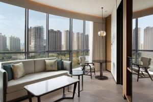 uma sala de estar com um sofá, mesas e janelas em Fairfield by Marriott Xi'an Chanba em Xian