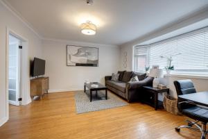 a living room with a couch and a tv at Eglinton West Guest Suite in Toronto