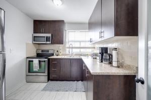 a kitchen with wooden cabinets and stainless steel appliances at Eglinton West Guest Suite in Toronto