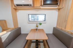 een kleine tafel in een kleine kamer met een raam bij Gapyeong Nami Island Marina Caravan in Chuncheon