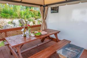 een houten picknicktafel op een terras met een paraplu bij Gapyeong Nami Island Marina Caravan in Chuncheon