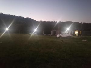 Ein weißes Auto parkt auf einem Feld mit drei Lichtern in der Unterkunft Eden in Queilén