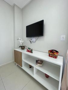 un soggiorno con TV su una parete bianca di Flats TAVARES ARAUJO 101 a Garanhuns