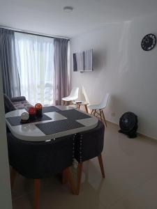ein Wohnzimmer mit einem Tisch und einem Sofa in der Unterkunft Apartamento Hogar fuera de casa in Armenia