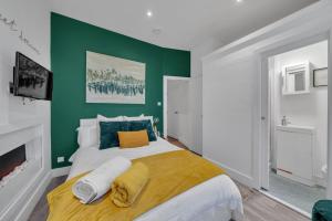 a bedroom with a large bed with a green wall at The Green Room in Sydenham