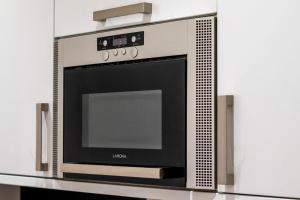 a microwave oven on a shelf in a kitchen at The Green Room in Sydenham