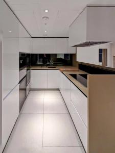a kitchen with white cabinets and a white floor at Soho West End in London