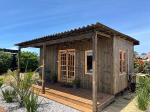 a wooden cabin with a wooden deck at BRASILEIRÍSSIMO POUSADA in Punta Del Diablo