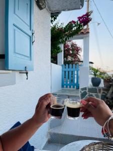 dos personas sosteniendo vasos de cerveza en una mesa en Su Casa KEA, en Korissia