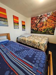 1 dormitorio con 2 camas y pinturas en la pared en valle, en Copiapó