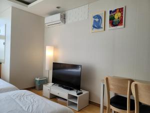 Schlafzimmer mit einem Bett, einem TV und einem Tisch in der Unterkunft Samsung Coex Daechi Gangnam House G in Seoul