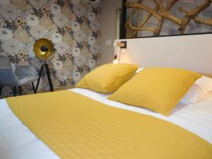 1 dormitorio con 1 cama con almohadas amarillas y lámpara en Gîte Laville-aux-Bois, 2 pièces, 2 personnes - FR-1-611-70, en Laville-aux-Bois