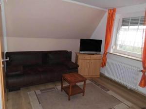 a living room with a couch and a tv at Holiday home Seehase in Ekel