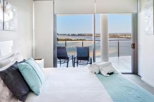 una camera da letto con un letto con vista sull'oceano di Monaco Caloundra a Caloundra