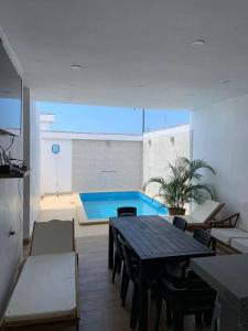 sala de estar con mesa y piscina en Hamaka Beach House en Boca del Charán