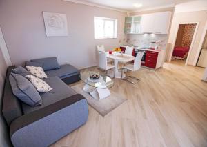 a living room with a couch and a table at Family-friendly apartments with swimming pool Banjol, Rab - 21952 in Banjol
