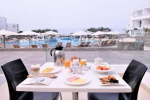 - une table blanche avec de la nourriture pour le petit-déjeuner à côté de la piscine dans l'établissement Casas y Dptos de Hotel, Acceso a VPX Hotel, AC, Parrilla y piscina privada, à Asia