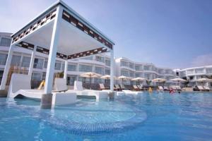 a swimming pool with white chairs and umbrellas at Casas y Dptos de Hotel, Acceso a VPX Hotel, AC, Parrilla y piscina privada in Asia