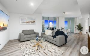 a living room with two couches and a table at Wings Apartments - QStay in Gold Coast