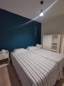 a bedroom with a large bed with a blue wall at T3 cosy, calme & lumineux proche Eurexpo, Groupama in Saint-Priest