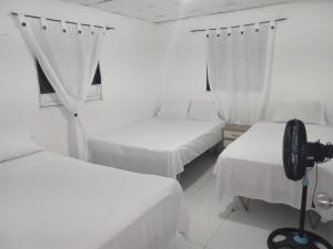 a room with three beds and a camera in it at HOSTAL BARRANQUILLA INN in Barranquilla