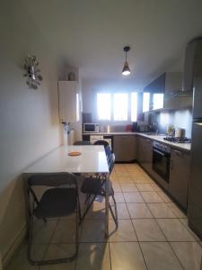 a kitchen with a white table and chairs in it at T3 cosy, calme & lumineux proche Eurexpo, Groupama in Saint-Priest +5 photos