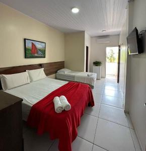 a bedroom with two white towels on a bed at Fazendinha Parque Raposa in Iguaíba