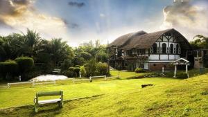 un bâtiment avec un banc devant une cour gazonnée dans l'établissement Sanita Cottage, à Chom Bung