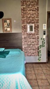 Off hostel floripa في فلوريانوبوليس: غرفة نوم بحائط من الطوب وسرير