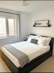 a bedroom with a bed with white sheets and a window at Cozy home in Brampton (Mt pleasant Go station) in Brampton